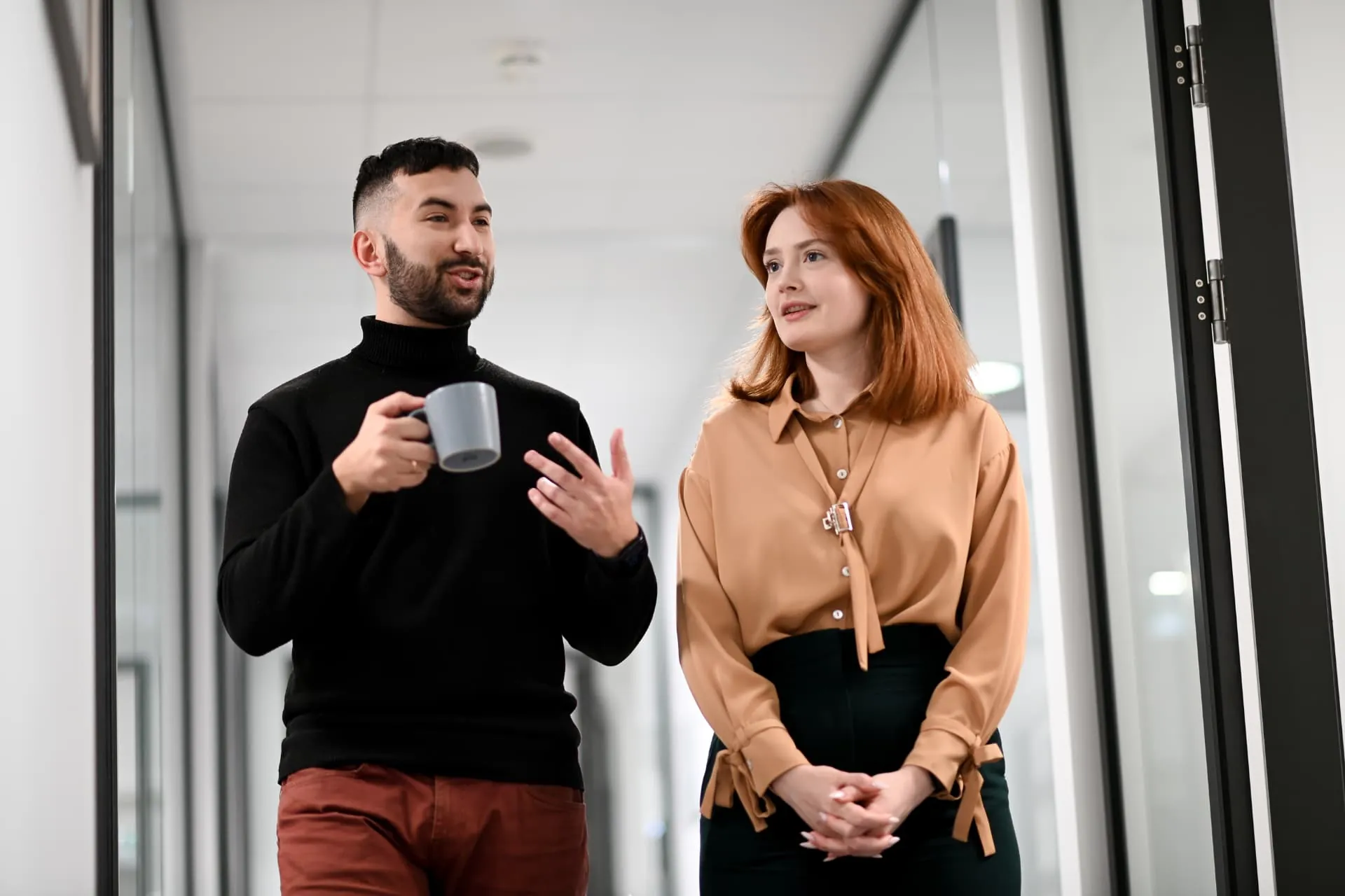 Two colleagues talking in the office corridor