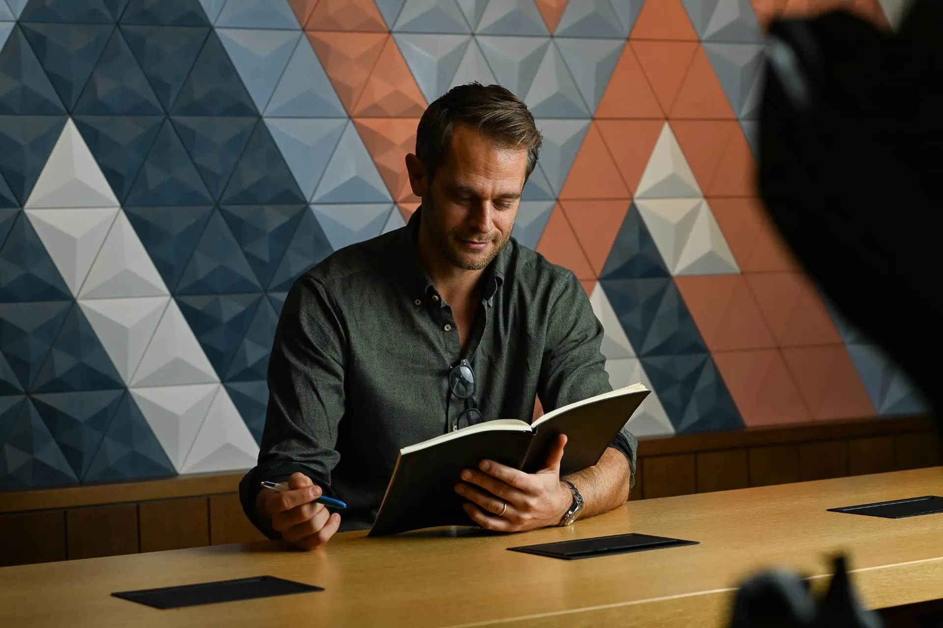 A colleague reading notes at a meeting table