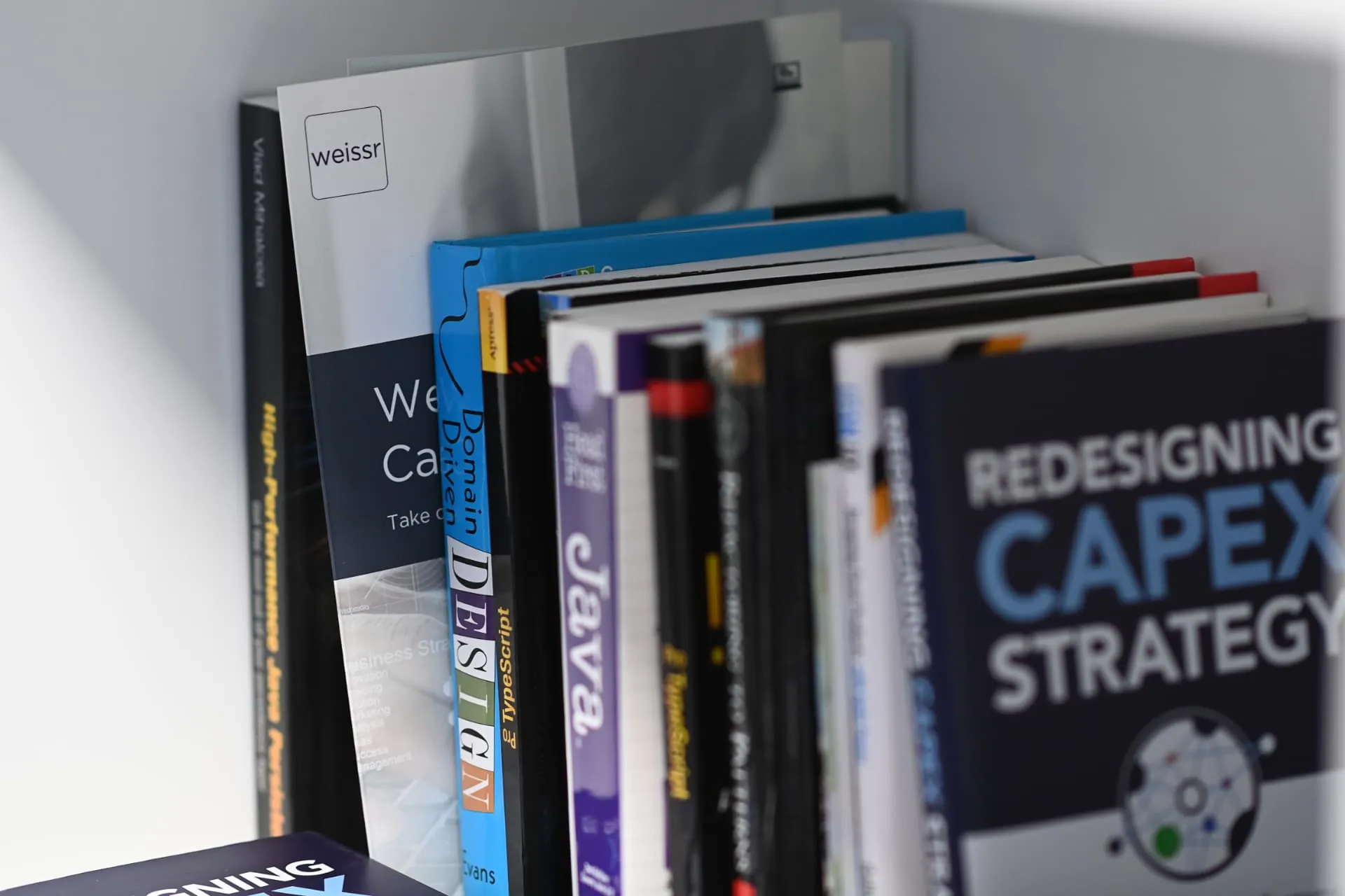 Books on Capex strategy and software on a Weissr shelf
