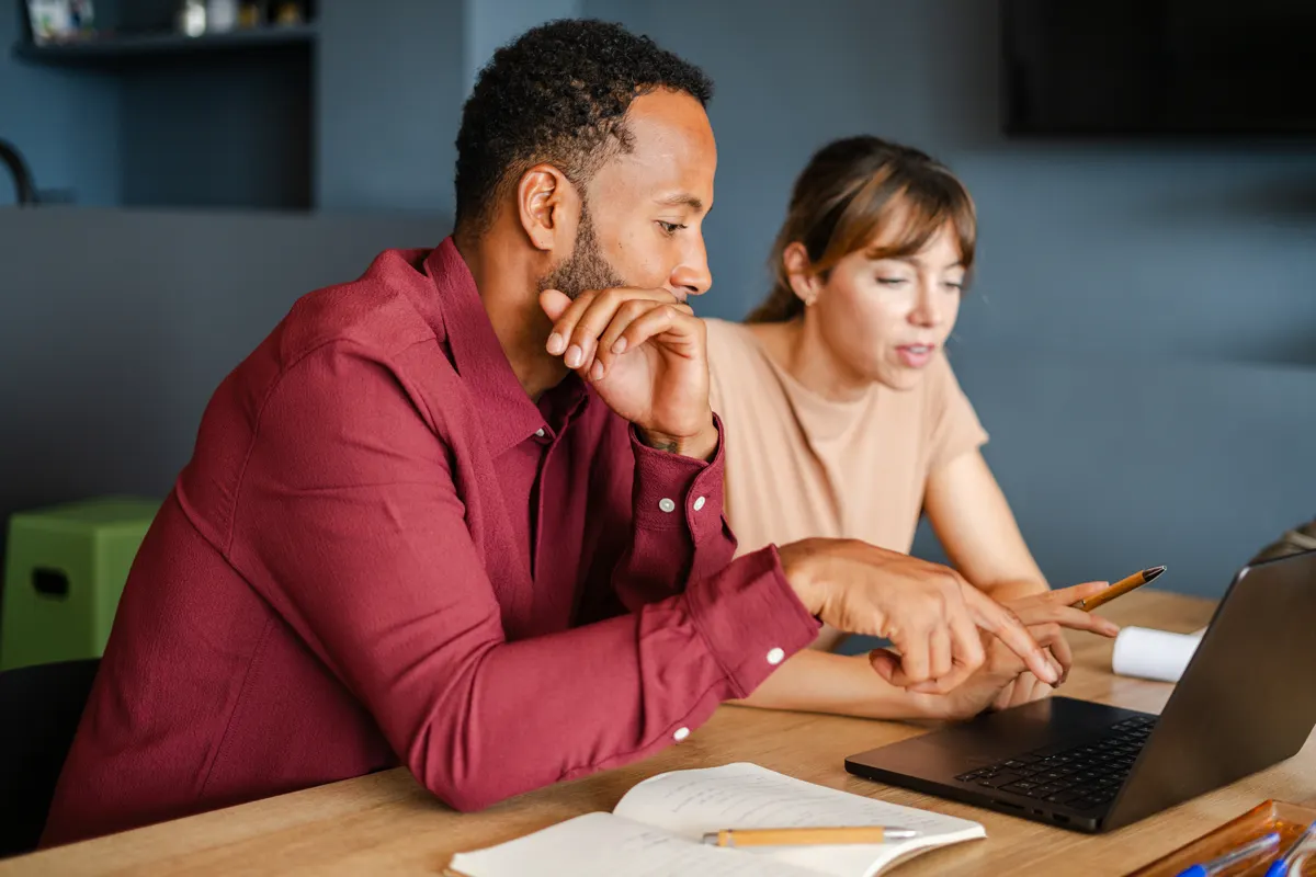 Two colleagues reviewing Capex software on a laptop